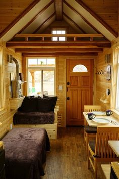 two beds in a small room with wooden walls and flooring on each side of the door