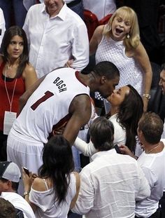 a group of people standing around each other at a basketball game