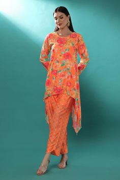 Orange chanderi high-low tunic with floral print and sequins, pearls and cutdana embroidery. Comes with pant.
Components: 2
Pattern: Printed, Embroidered
Type Of Work: Floral, Sequins, Pearls, Cutdana
Neckline: Round
Sleeve Type: Full
Fabric: Chanderi, Lining : Shantoon
Color: Orange
Other Details: 
Attached lining
Length :
Tunic : 28 inches (Front), 45 inches (Side)
Pant : 38 inches
Product Weight : 1 Kg
Closure : Tunic - Back hook
Occasion: Sangeet - Aza Fashions Silk Sets With Printed Motifs In Maxi Length, Silk Maxi Sets With Printed Motifs, Eid Party Palazzo Set With Printed Motifs, Designer Spring Kurta With Sheer Dupatta, Eid Maxi Length Palazzo Set With Printed Motifs, Eid Festival Maxi Length Printed Palazzo Set, Designer Kurta With Sheer Dupatta For Spring, Festive Summer Straight Kurta Pant Set, Eid Palazzo Set With Printed Motifs Maxi Length