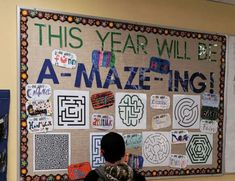 a man standing in front of a bulletin board with writing on it that says this year will be a - mazeing