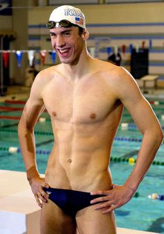 a man standing in front of a swimming pool with his hands on his hips and smiling