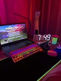 a laptop computer sitting on top of a desk next to a mouse and keyboard in front of a red curtain