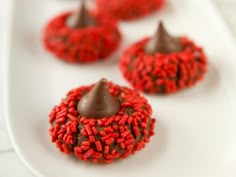 some red and brown desserts on a white plate