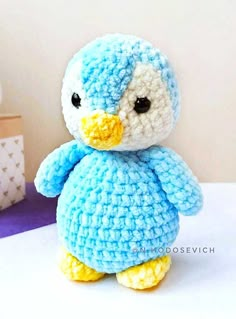 a crocheted blue bird sitting on top of a table