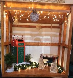 a christmas display with lights and decorations on the wall, including a small bench that has a chalkboard attached to it