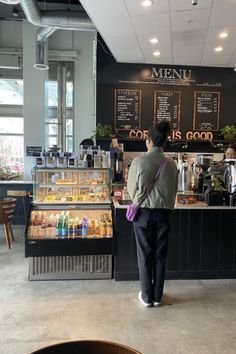 a person standing in front of a counter with food on it and menus behind them