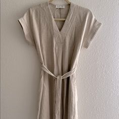 Size Small. Natural Linen Dress. New, Never Worn. Has Waist Tie And Pockets! Neutral Cotton Short Sleeve Dress, Beige Relaxed Fit Dress For Day Out, Beige Relaxed Fit Midi Dress For Vacation, Short Sleeve Neutral Dress For Day Out, Casual Neutral Relaxed Fit Dress, Neutral Short Sleeve Midi Dress For Beach, Neutral Short Sleeve Mini Dress For Beach, Summer V-neck Dress In Neutral Color, Neutral V-neck Dress For Vacation