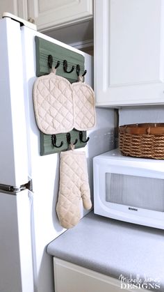 an oven mitt hanging on the side of a refrigerator