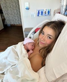 a woman laying in a hospital bed holding a baby