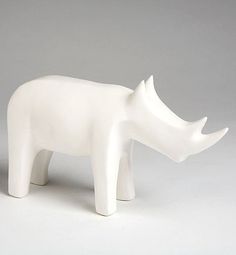 a white rhino figurine on a gray background