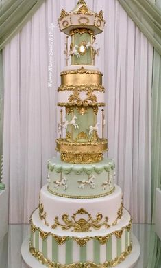 a three tiered cake with gold trimmings and decorations on the top layer