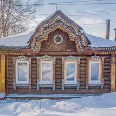 an old log house with snow on the ground