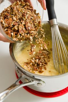 a person mixing food in a pot with a whisk