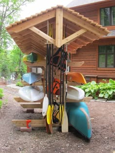 several kayaks are stacked up in front of a log cabin