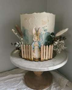 a cake decorated with an image of a rabbit and feathers on top of a table