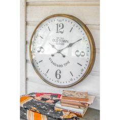 an old town clock is on the wall next to some quilts and books in front of it