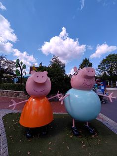 two inflatable peppoins are standing on the grass