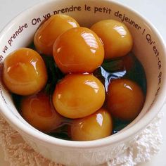 a white bowl filled with oranges on top of a table