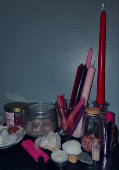 candles, seashells and other condiments are arranged on a black table