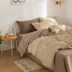 a bed sitting in a bedroom next to a wooden table with a plant on it