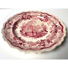 a red and white plate with an image of a castle on the side, sitting on top of a table