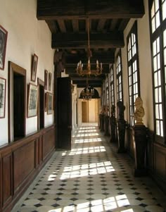 a long hallway with lots of windows and pictures on the wall