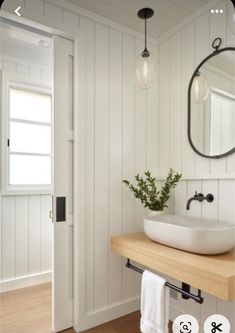 a bathroom with a sink, mirror and light fixture on the wall next to it