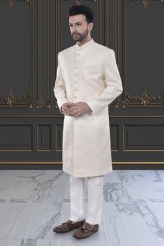 This Mens Sherwani is crafted in brocade, providing a luxurious and elegant touch. The intricate design and high-quality material make it perfect for special occasions and cultural events. Experience high-end fashion and traditional style with our Mens Sherwani - M42-S132. Elegant Beige Traditional Wear With Zari Work, Long Embroidered Elegant Nehru Jacket, Embroidered Long Elegant Nehru Jacket, Elegant Long Embroidered Nehru Jacket, Elegant Off White Sherwani With Resham Embroidery, Elegant Cream Traditional Wear For Festive Occasions, Elegant Cream Sherwani With Intricate Embroidery, Ceremonial Cream Nehru Jacket With Zari Work, Classic Sherwani For Wedding And Festive Occasions