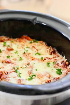 a crock pot filled with cheese and meat