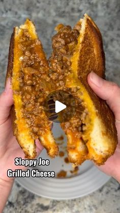 someone is holding up a sloppy joe grilled cheese sandwich to take a bite out