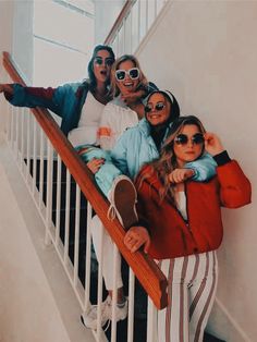 a group of young women standing on top of a stair case next to each other