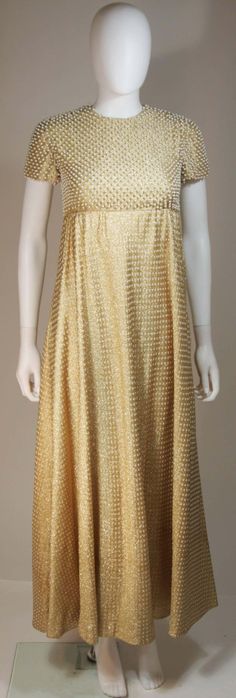 For Sale on 1stDibs - This Geoffrey Beene gown is composed of a gold metallic knit with polka dot design, and hand beaded small pearl bodice. Gown is lined in soft white silk.