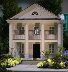 a doll house is shown with flowers around it