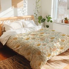 a bed sitting in a bedroom next to a window with potted plants on it