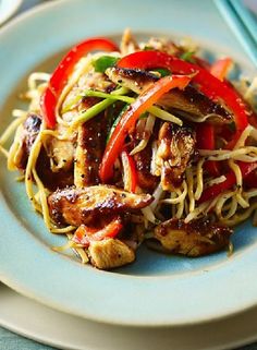 a white plate topped with meat and veggies next to chopsticks on a table