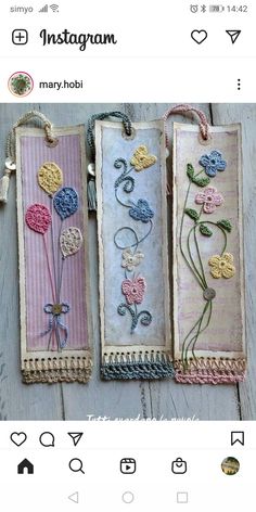 three bookmarks with flowers on them hanging from strings