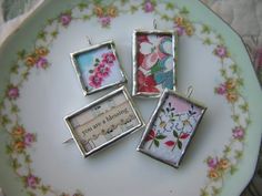 four small frames are sitting on a plate with flowers and words in the frame,