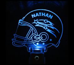 a football helmet with the name nathan on it is lit up in blue and white