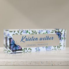 a business card with a blue butterfly on it and the words, kristen welker general manager