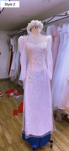 a mannequin dressed in a white dress with long sleeves