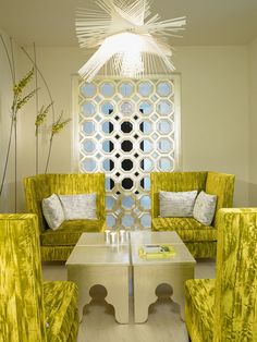 a living room filled with furniture and a white ceiling light hanging over the top of it