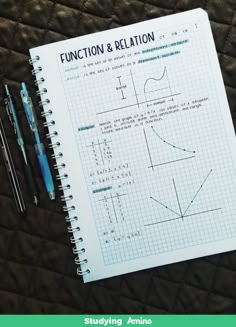 a notebook and pen sitting on top of a table next to a calculator