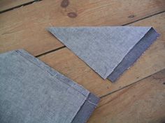 two pieces of gray fabric sitting on top of a wooden floor next to each other