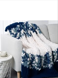 a blue and white blanket sitting on top of a couch