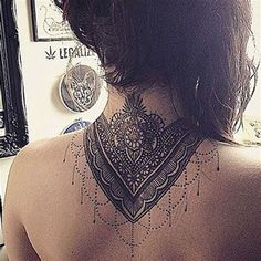 the back of a woman's neck is adorned with intricate designs and tattoos on it