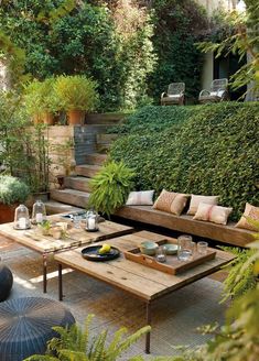 an image of a living room with couches and tables in front of some bushes