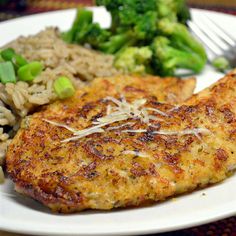 a white plate topped with meat, rice and broccoli next to a fork