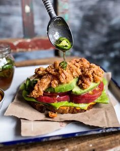 a sandwich is being drizzled with something green on the top and bottom