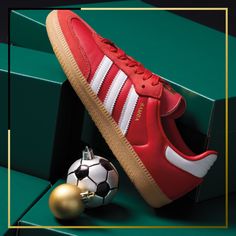 a pair of red adidas sneakers next to a soccer ball and christmas ornament