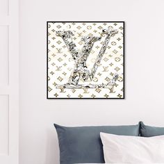 the letter y is made up of louis vuitton letters on a white wall above a bed